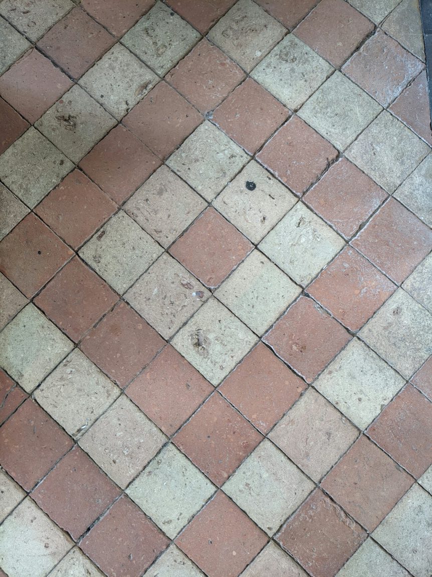 Close-up of buff and red aged terracotta tiles laid on the diagonal