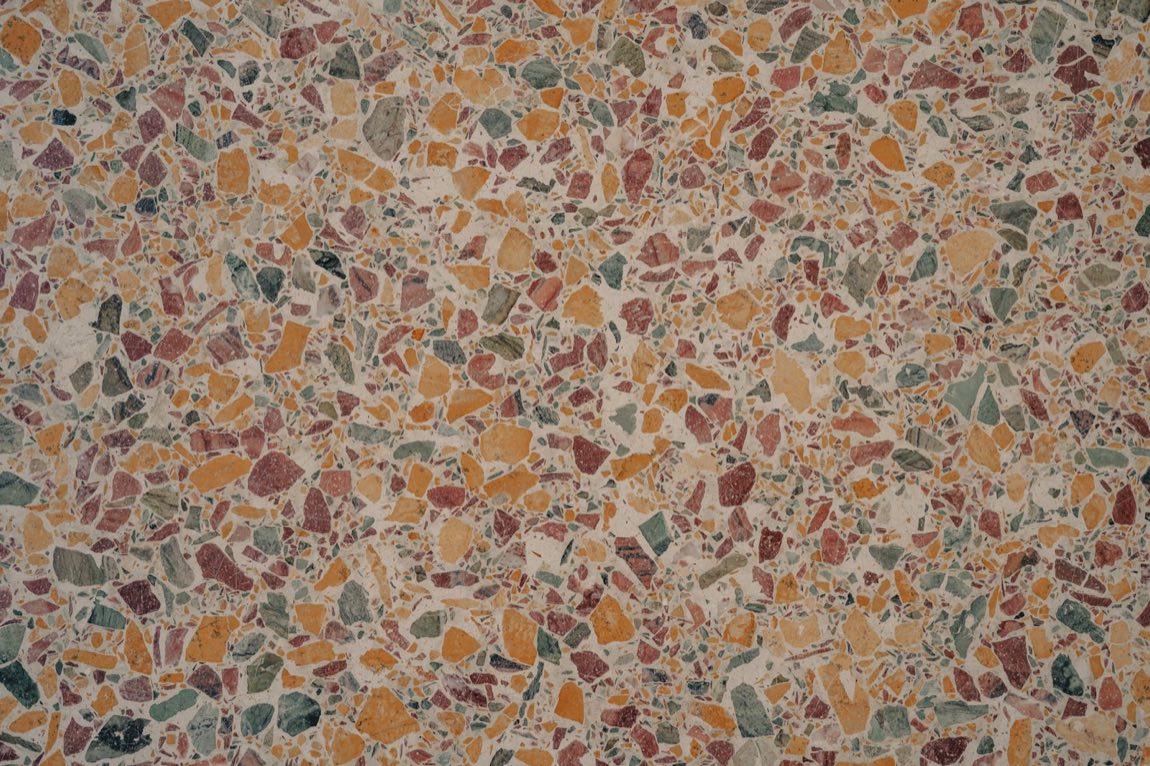 Close-up of warm terrazzo with amber, red and green stone chips